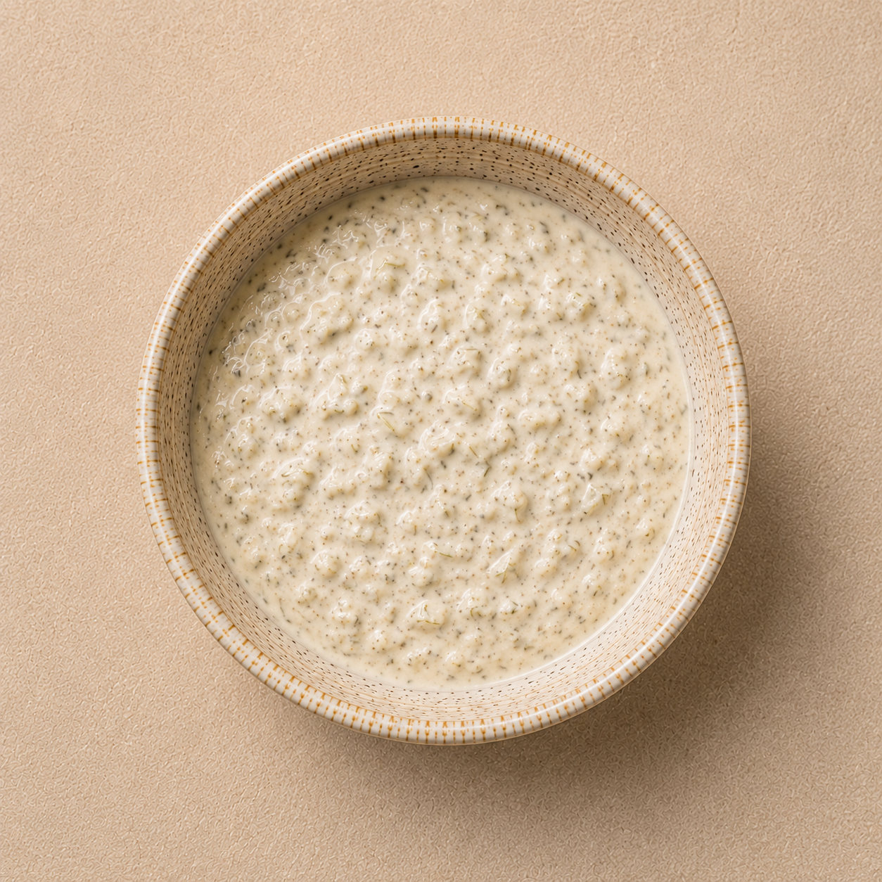 Creamy house tartar sauce with grated pickles in a ceramic bowl.