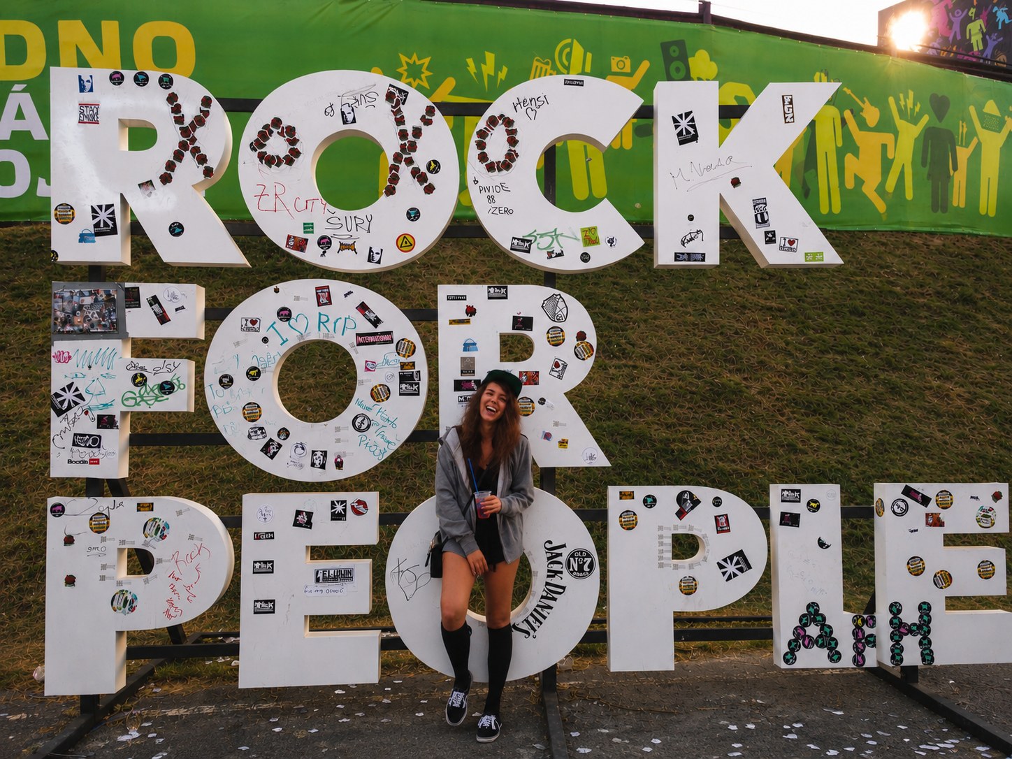 A festival photo showing the person behind Skin ’n Roll in front of a large festival sign.